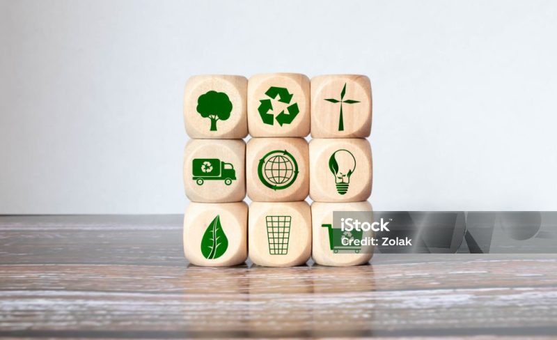 senior's hand holding heart with earth icon on wood cube health world ,CSR, eco green sustainable living, zero waste, earth day, world environment day, responsible consumption Social responsibility