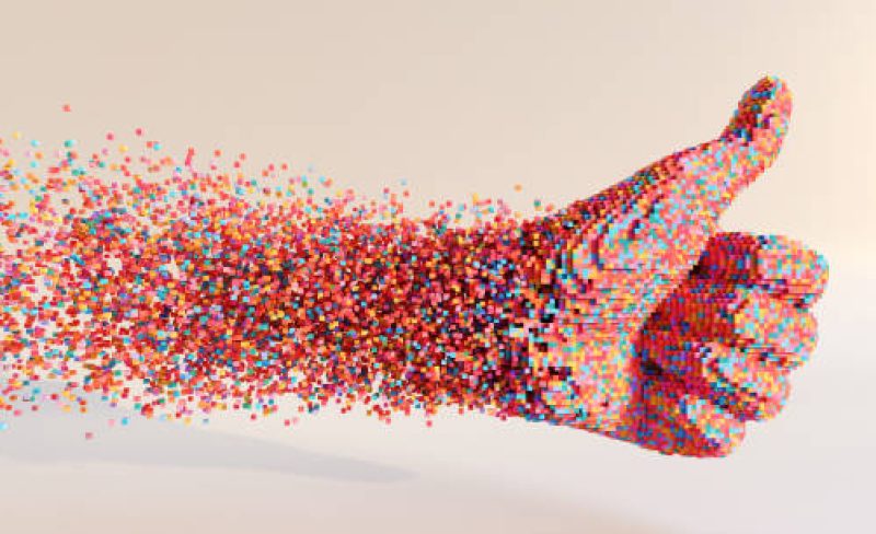 An abstract image of hundreds of small multi-coloured cubes moving through space to form a thumbs up symbol, against a plain light background. With copy space.